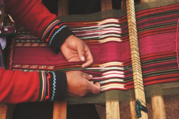 Des mains sur un métier à tisser