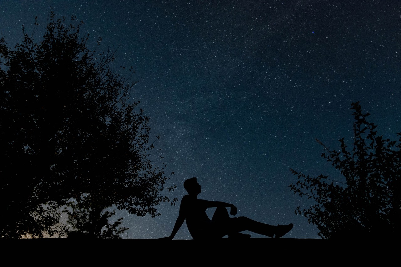 Un homme médite sous les étoiles